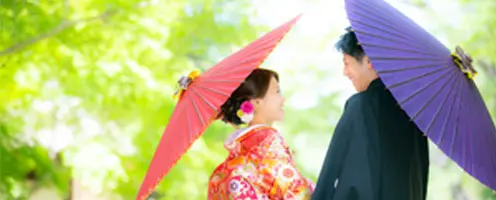撮影サービス一覧へ移動するためのリンク写真|和服を着た結婚式の前撮りをする男女が倉敷のきれいな緑の中で見つめ合っている